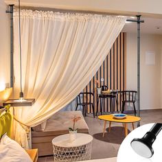 a living room filled with furniture and a white drape over the window next to a coffee table