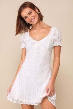 You'll twirl your way into everyone's hearts in the Sent to Charm White Textured Ribbon Puff Sleeve Mini Dress! This adorable dress features a textured mesh overlay that shapes short puff sleeves with smocked, fitted cuffs. Bodice boasts a sweetheart neckline and embroidered detailing, with a satin ribbon that ties at the frontâ€”all atop an empire waist. The figure-skimming skirt has a flaring, A-line silhouette and ends at a mini hem. Hidden zipper/clasp at back. Fit: This garment fits true to Engagement Party Dresses, Spring Wedding Dress, Puff Sleeve Mini Dress, Adhesive Bra, Mesh Overlay, Puff Sleeve Dresses, Summer 24, Short Wedding Dress, Strapless Bra