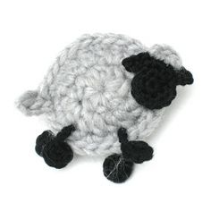 a crocheted sheep with black feet is shown in front of a white background