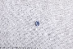 a close up of a blue spot on a white cloth