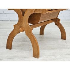 a wooden bench sitting on top of a tile floor next to a brick wall and white tiles