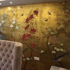 a wall with flowers painted on it and birds flying over the top, in a restaurant