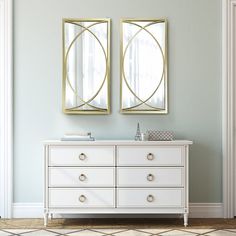 two mirrors on the wall above a white dresser