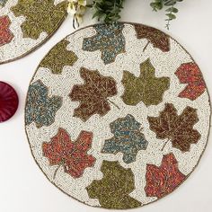 two coasters with leaves on them next to flowers