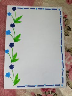 a piece of paper with blue flowers on it and green leaves painted on the side