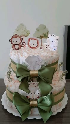 a three tiered cake decorated with animals and ribbons on top of a wooden table