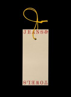 a white paper bag with a yellow string hanging from it's side on a black background