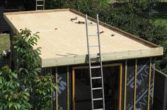 a ladder is attached to the roof of a small building that's being built