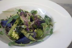 a white plate topped with broccoli and other vegetables