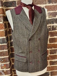 A uniquely designed, mens double breasted brown and deep red tweed waistcoat with a mock-suede collar.  Item is beautifully designed with Burgundy suede edging on the pockets and collar, and can be closed via three buttons on the front of the waistcoat.  This waistcoat as you can see has a unique back with a paisley design also in a deep red burgundy colour. The waistcoat can be adjusted with a button system adjustment also shown. This is ideal for a wedding or casual wear, great with a suit or a pair of jeans. Please see our online etsy shop to view our range of Tweed products for that perfect winter look. Fitted Single-breasted Tweed Vest, Winter Brown Tweed Vest, Formal Brown Tweed Vest, Brown Tweed Vest For Winter, Fitted Brown Double-breasted Tweed Jacket, Fitted Double-breasted Brown Tweed Jacket, Brown Fitted Double-breasted Tweed Jacket, Tailored Brown Tweed Vest, Brown Semi-formal Vest With Notch Lapel