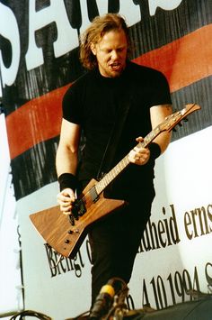 a man playing an electric guitar in front of a sign that says savig