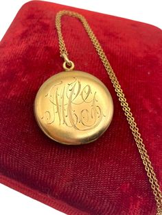 Description: A beautiful, round and shiny antique locket.  This gold filled locket features a monogrammed front with the initials "MCG" or "MIG" (it's open to interpretation) in an old, swirling cursive script. The back side of this circa early 1900s locket is plain with no decoration and has a hiny finish.  The locket opens from the top and has a hinge on the bottom. This type of monogrammed item was very popular during the Edwardian era.   There are two photo compartments inside this antique locket. Both wells have the frame and the original plastic covers and paper backings still intact. The bale is a plain loop. The locket closes securely. The vintage locket hangs on a vintage 20" long 14k GF cable chain that is vintage. The chain is marked as 14K gold filled. The chain has a spring ri Vintage Locket, Antique Locket, Cursive Script, Large Necklace, Vintage Lockets, Photo Pendant, Edwardian Era, Early 1900s, Locket Necklace