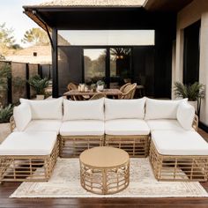 an outdoor living room with white couches and tables