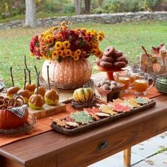 a wooden table topped with lots of different types of food and desserts on top of it