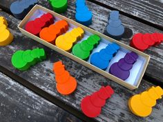 an open box filled with different colored plastic toys on top of a wooden table,