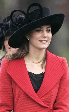 a woman wearing a red coat and black hat