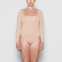 An ultra-chic and flattering long sleeve bodysuit that is made to be a staple in your wardrobe. Features a raw cut scoop neckline and a light level of compression. Long Sleeve Second-skin Smoothing Bodysuit, Smoothing Bodysuit With Minimal Stretch For Loungewear, Seamless Second-skin Bodysuit For Loungewear, Second-skin Shapewear Bodysuit For Loungewear, High Stretch Seamless Long Sleeve Bodysuit, Seamless High Stretch Long Sleeve Bodysuit, Long Sleeve Stretch Seamless Leotard, Seamless Long Sleeve High Stretch Bodysuit, Seamless Second-skin Long Sleeve Bodysuit