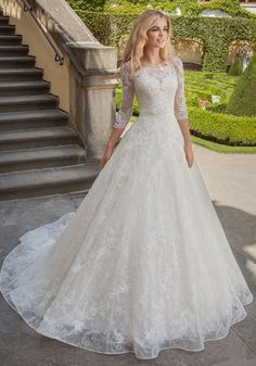 a woman in a wedding dress standing on stairs