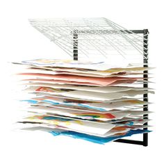 a stack of papers sitting on top of a metal rack next to a white wall