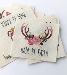 four tags with deer antlers and flowers on them are printed onto white fabric, which reads made by kayla