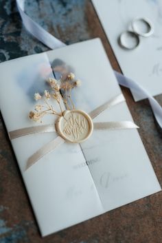 a wedding card with a ring on it and a ribbon tied around the back of it