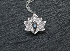 Lotus Necklace is unique handmade piece made of sterling silver and gorgeous Labradorite cabochon. Water lily symbol is a powerful message for your beloved one. Lotus symbolizes true Love, Devotion, Empathy. It's associated with Heart chakra and can be used for meditation and spiritual practices. Please note, it's handmade made to order piece. Some details of your piece may slightly vary from the one in the picture.  Gemstone: Rainbow Moonstone Dimensions: Lotus Flower is 2.8 * 2.8 cm (1.1 inch Lily Symbol, Yoga Pendant, Lily Necklace, Yoga Necklace, Lotus Jewelry, Lotus Necklace, Lotus Pendant, Black Gold Jewelry, Chakra Necklace