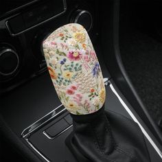 the interior of a car with a colorful flower print on it's center console