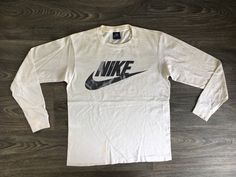 80's Blue Tag Nike Shirt. A classic longsleeve with a black & white color combo. There's some sweet distressing on the print. Some marks and one very small hole. Overall fair condition. 100% cotton that is soft and has that high-quality old cotton feel. Timeless Nike style. See more vintage Nike tees in my shop https://www.etsy.com/shop/sweetVTGtshirt?section_id=11916484&ref=shopsection_leftnav_4 Label: Nike Blue Tag. USA Made Measurements: Inches Chest/Bust: 18 1/2 Bottom Hem: 18 1/2 Sh Retro Long Sleeve Sports T-shirt, Sportswear Long Sleeve T-shirt With Logo Print, 90s Long Sleeve Tops With Logo Print, 90s Style Long Sleeve Top With Logo Print, Vintage Long Sleeve Top With Logo Print, Long Sleeve Graphic Print Sportswear T-shirt, 90s Long Sleeve T-shirt With Logo Print, Retro Long Sleeve T-shirt With Logo Print, Retro Long Sleeve T-shirt For Streetwear