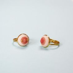 two rings with pink and yellow designs on them sitting next to each other in front of a white background