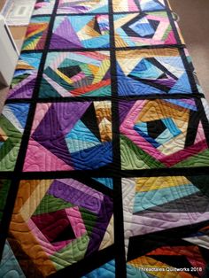 a colorful quilt is laying on the floor