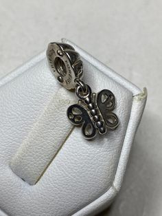 "The retired vintage Pandora \"Friends Forever\" butterfly charm is a beautiful and timeless piece of jewelry that makes for a thoughtful and sentimental gift for her. The charm is crafted from high-quality sterling silver, ensuring that it will last for years to come. As a vintage item, the charm may show some signs of wear and tear, which only adds to its charm and character. Despite this, the charm remains in good condition, ready to be added to her Pandora bracelet collection. The butterfly Elegant Sterling Silver Charms For Gifts, Elegant Silver Bracelet With Butterfly Charm, Silver Dainty Charms, Silver Elegant Charms For Gifts, Elegant Silver Charms For Gift, Silver Dainty Butterfly Bracelets, Elegant Silver Butterfly Bracelets, Elegant Hypoallergenic Charms For Gifts, Dainty Silver Butterfly Bracelets