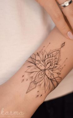 a woman's arm with a flower tattoo on it