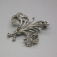 A gorgeous antique / vintage 835 silver brooch with natural faceted marcasite stones. Intricately detailed leaf and flower bouquet design. This lovely silver pin was made in continental Europe circa 1930's. The brooch will be shipped in a gift box. The brooch measures about 1 2/3 inches (4.1 cm) long Width at its widest point: 1 1/3 Inches (3.3 cm) Weight: 7.6 grams Rollover clasp Excellent condition, all marcasites are present. Hallmarked for 835 silver. The standard shipping for this item is w Silver Victorian Brooches For Vintage Events, Silver Victorian Brooch For Vintage Events, Victorian Silver Brooch For Vintage Events, Victorian Antique Silver Wedding Brooches, Vintage Marcasite Jewelry For Gift, Vintage Marcasite Silver Jewelry, Silver Vintage Flower Brooches, Art Nouveau Silver Brooch, Marcasite Jewelry