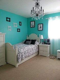 a bedroom with blue walls and white furniture