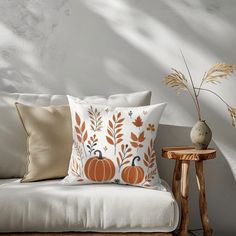 a white couch sitting next to a wooden table with a vase on top of it