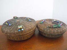 two wicker baskets sitting on top of a wooden table next to each other with beads in them