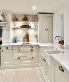 a kitchen with white cabinets and counter tops