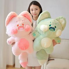 the woman is holding two large stuffed animals