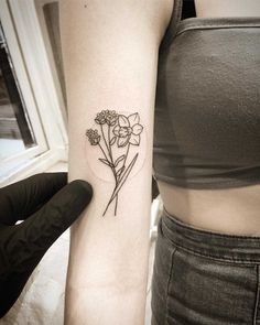 a woman's arm with a flower tattoo on the left side of her arm