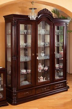 the china cabinet has many glass doors and drawers on it's sides, as well as