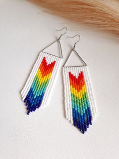 Celebrate love and inclusivity with these stunning Pride Jewellery Rainbow Earrings. Each earring is a cascade of color, meticulously handcrafted with seed beads to create a vibrant fringe that captures the spirit of pride. These Beaded Earrings boast long, colourful dangles that make a bold statement, ideal for both everyday wear and pride parades. Designed with stainless steel hooks, they ensure a comfortable experience for everyone, including those with sensitive ears. These Statement Jewellery pieces are not just accessories; they are a celebration of diversity and a nod to Boho Earrings style. Wear them with pride and let these Rainbow Fringe Earrings add a burst of joy to any outfit. Dimensions: Approximately 4.5in / 11cm long with the hooks I am pleased to inform you that all my ite Rainbow Fringe, Seed Bead Fringe Earrings, Bead Fringe Earrings, Dance Earrings, Pride Jewellery, Bead Fringe, Festival Earrings, Boho Style Earrings, Bohemian Jewellery