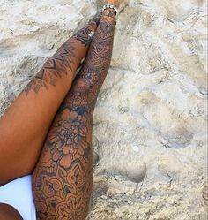 a woman laying on top of a sandy beach