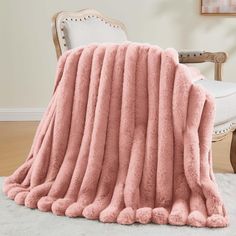 a large pink blanket sitting on top of a chair