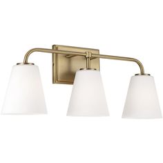 three light bathroom fixture in an antique brass finish with white glass shades on the sides