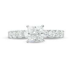 an engagement ring with a princess cut diamond in the center and side stones on each band