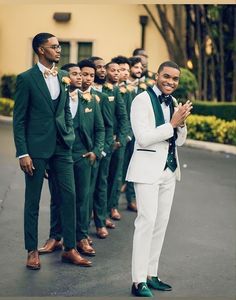 a group of men in green and white suits standing next to each other with their hands together