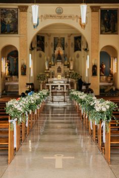 an empty church with pews and flowers on the sidelines in front of it