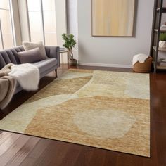 a living room area with a couch, chair and rug on the hardwood flooring