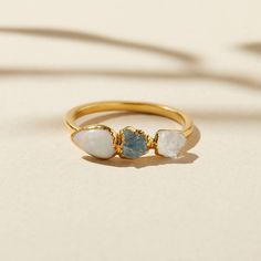 Do you believe in magic? With this delicate opal ring with raw aquamarine and quartz stones on your hand, you just may. Low-key enough for every day, elevated enough for your most treasured moments, it grounds outfits and occasions with a peaceful simplicity. This heirloom piece is handmade to accompany you through your journey, and inspires with its centering hues. In mystical circles, opal is considered a stone representing hope, innocence and purity. It has strong connotations of joy, faithfulness, loyalty, and confidence. We’ll take it all. Opal is October's birthstone: a symbol of hope, clarity, and truth. Aquamarine is May's birthstone: a symbol of tranquility, clarity, and courage. Quartz is April's birthstone: the ability to help with higher attunement and spiritual growth. -Width Engagement Ring Aquamarine, Raw Opal Ring, Gold Opal Ring, Opal Stacking Ring, Rough Quartz, October Birthstone Ring, Raw Diamond Rings, Alternative Wedding Rings, Raw Aquamarine