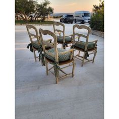 four chairs sitting on top of a cement floor next to each other in front of a parking lot